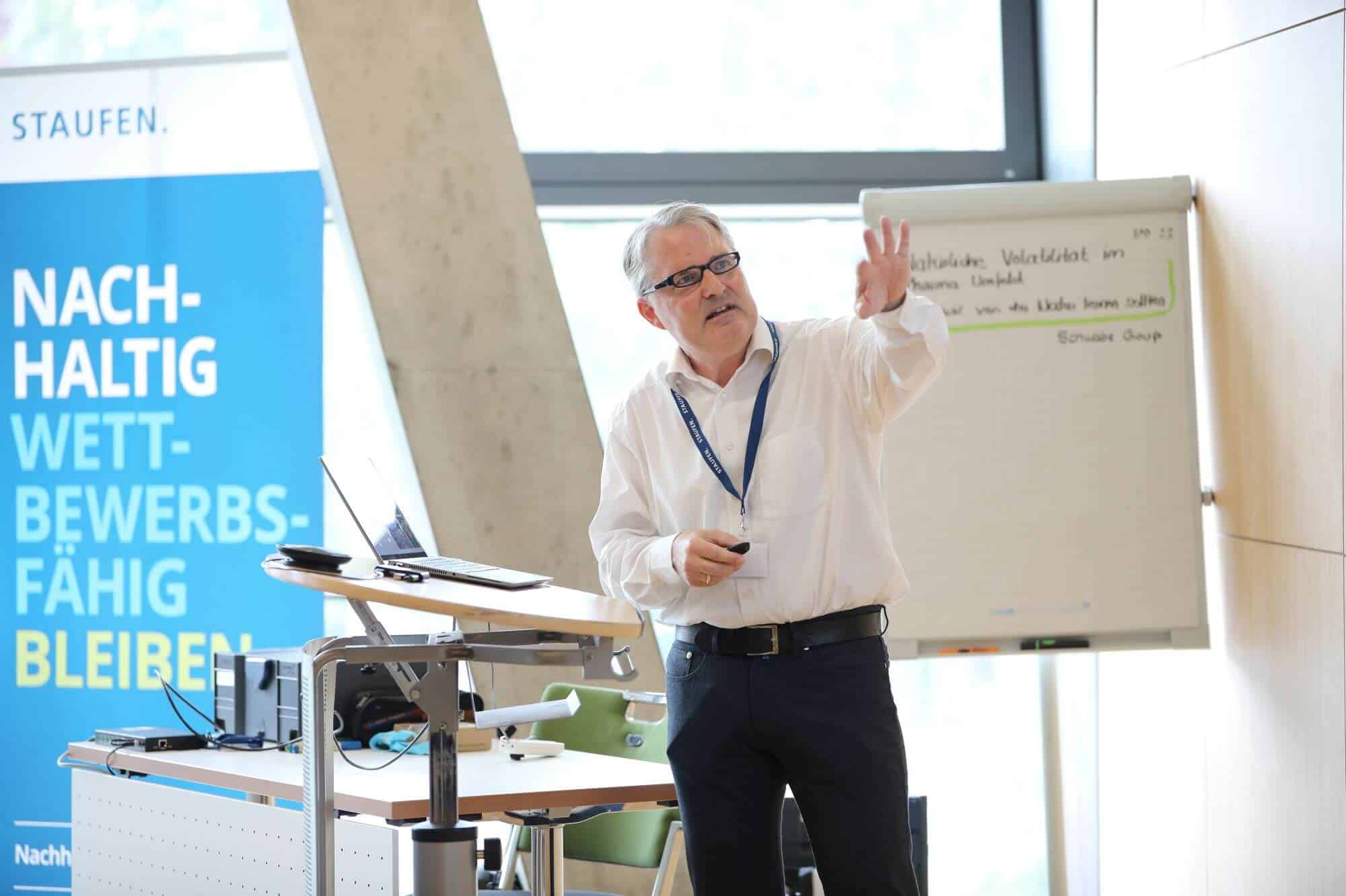 Dr Harald Orth speaking and pointing to a screen