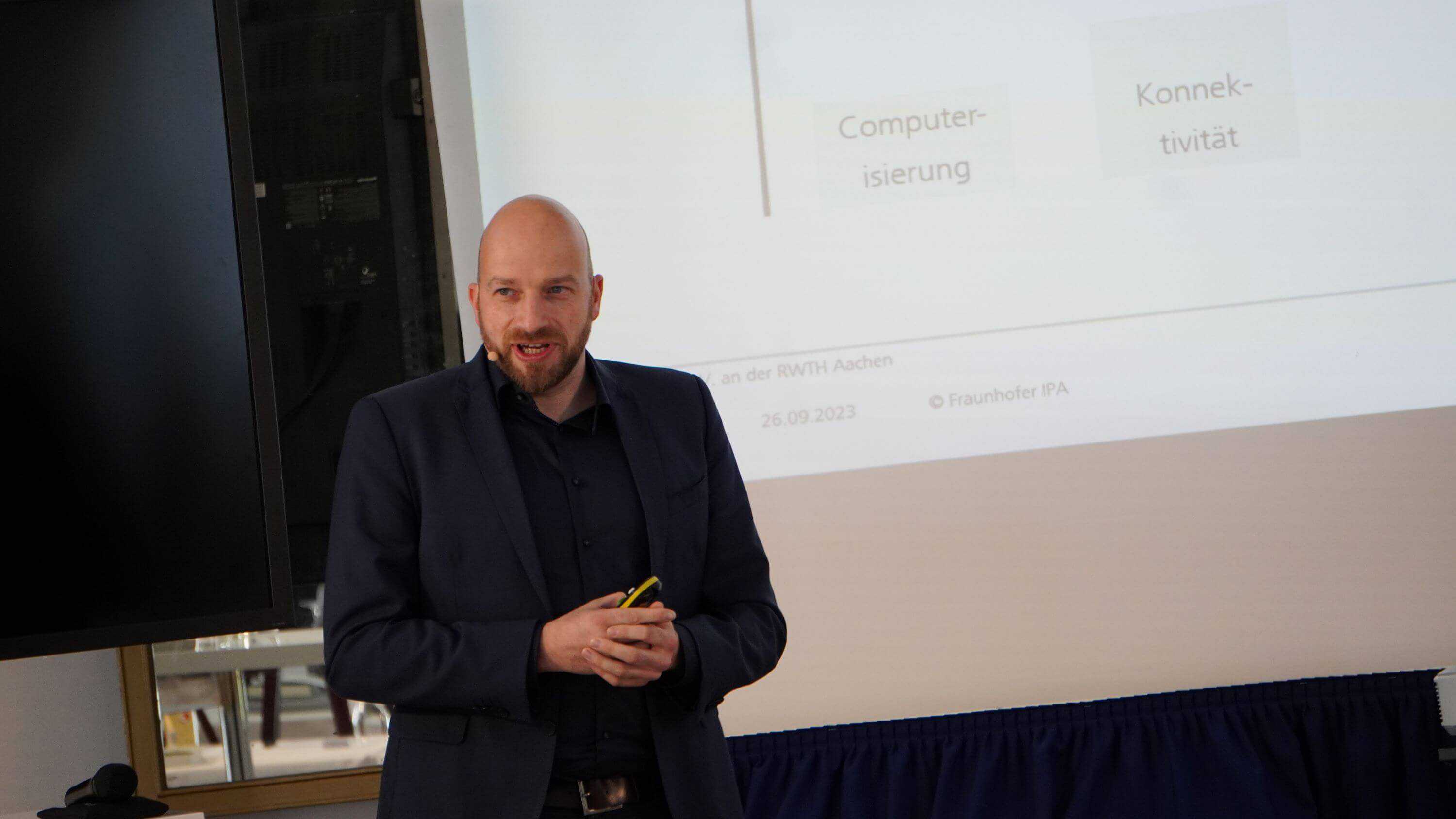 Man (Marco Huber) presenting infront of a Screen