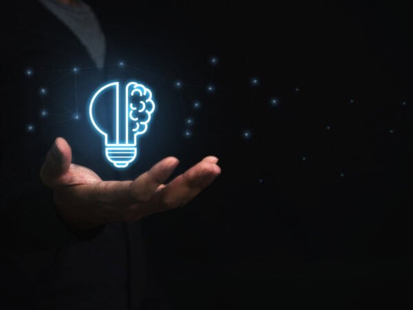 Businessman holding virtual light bulb and half brain on blue bokeh background smart thinking concept and innovative ideas inspired