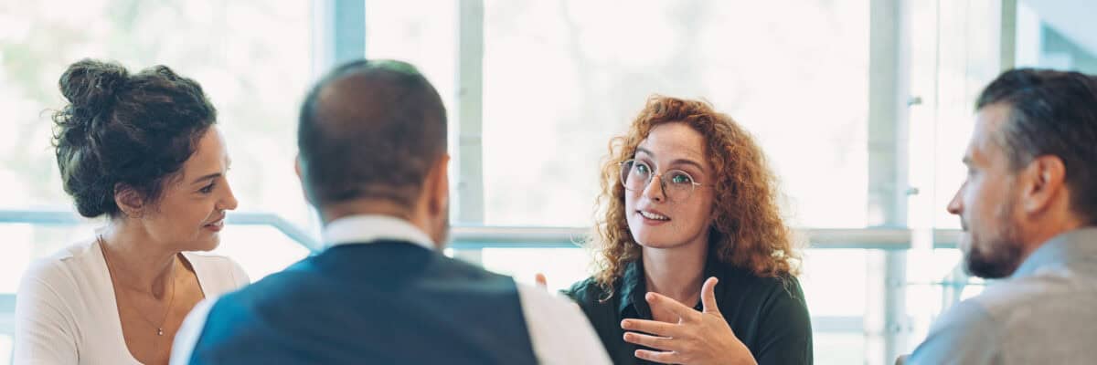 Business persons sitting around a table and talking
