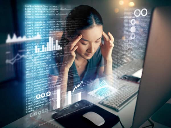 Shot of a young programmer looking stressed while using a computer at night in a modern office